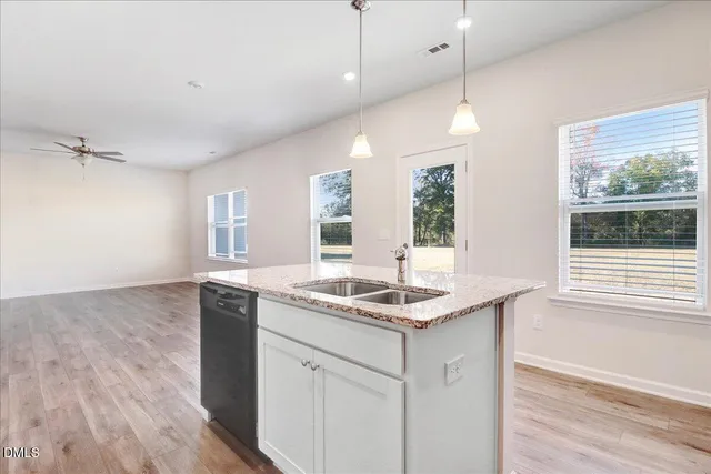 a kitchen with a sink chandelier and wooden floor