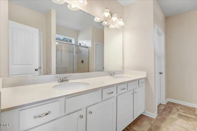 a bathroom with a double vanity sink and a mirror