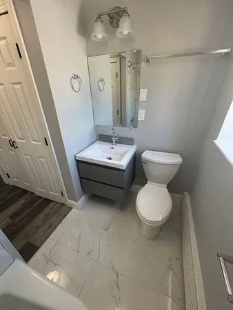 a bathroom with a toilet sink and mirror