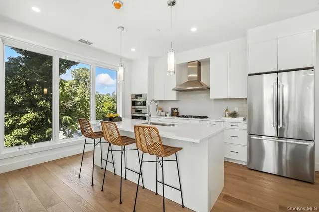 a kitchen with stainless steel appliances white cabinets and wooden floors
