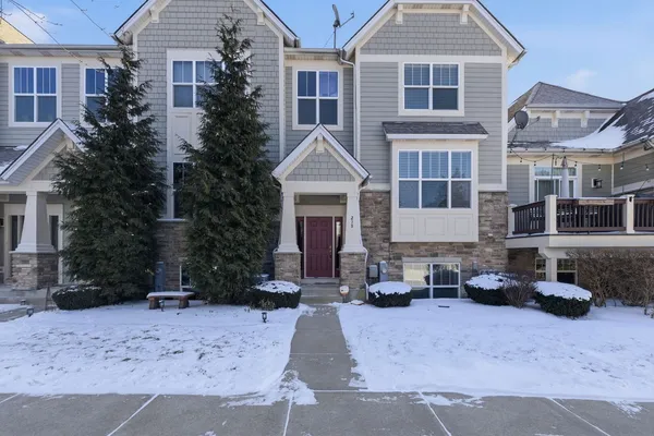 a front view of a house with cars parked