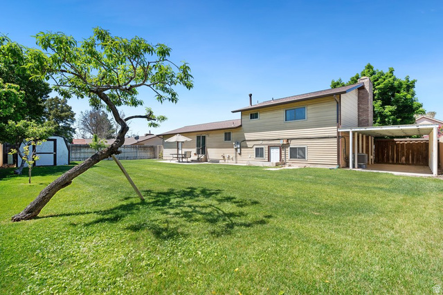 865 South 325 West Orem, UT 84058 - Photo 35 of 38 Spacious backyard with a large lawn, mature tree, and a shed & fruit trees