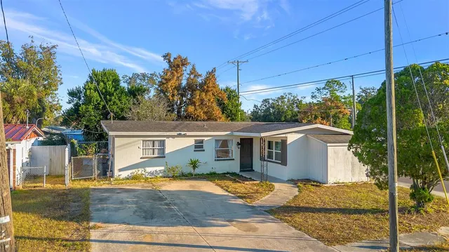 a view of a house with backyard and trees