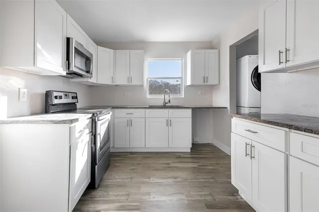 a kitchen with stainless steel appliances granite countertop a stove a sink and a refrigerator