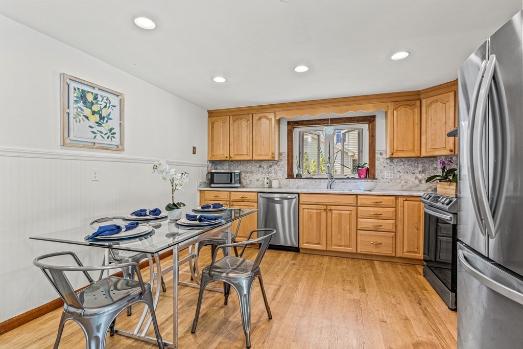 11 Main Street Winchester, MA 01890 - Photo 11 of 41 a kitchen with stainless steel appliances granite countertop a stove a sink dishwasher and a refrigerator with wooden floor