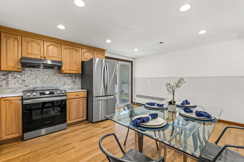 11 Main Street Winchester, MA 01890 - Photo 13 of 41 a kitchen with stainless steel appliances granite countertop a stove a sink dishwasher and a refrigerator with wooden floor