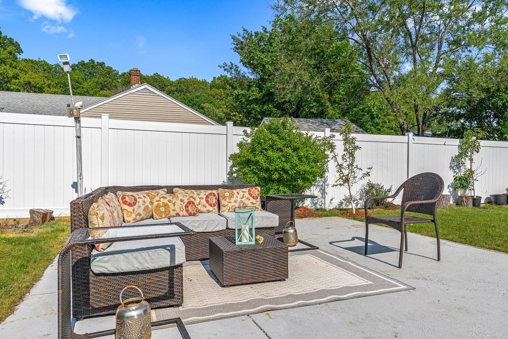 11 Main Street Winchester, MA 01890 - Photo 32 of 41 a view of a patio with couches table and chairs with potted plants and a big yard
