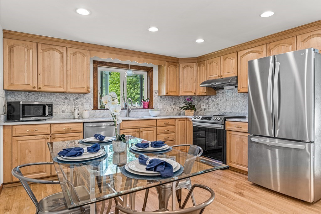 11 Main Street Winchester, MA 01890 - Photo 9 of 41 a kitchen with stainless steel appliances a stove a refrigerator and a stove with wooden floors