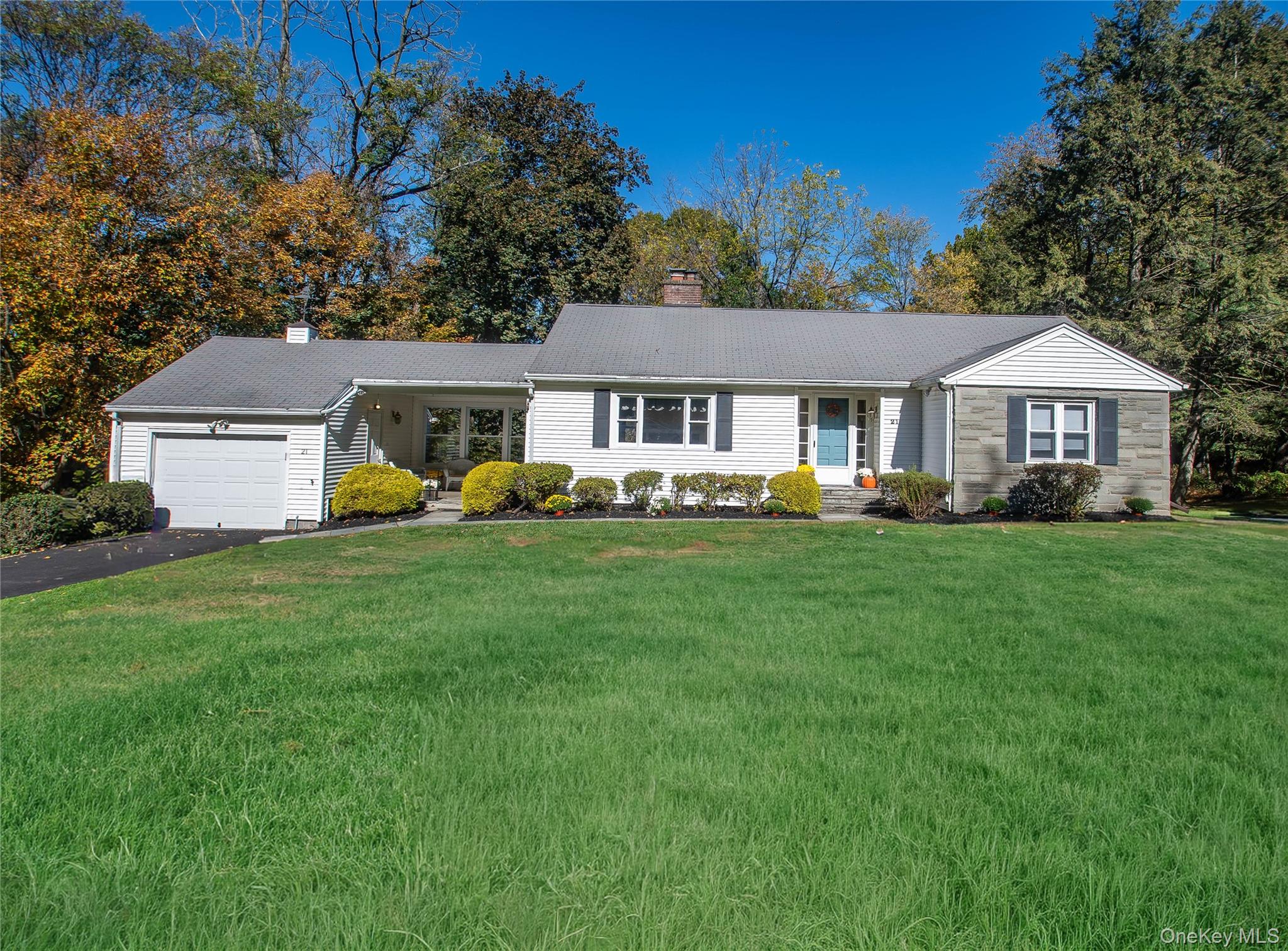 a front view of a house with a garden and trees