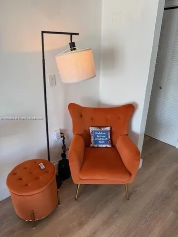 a blue bed sitting next to a chair and a lamp