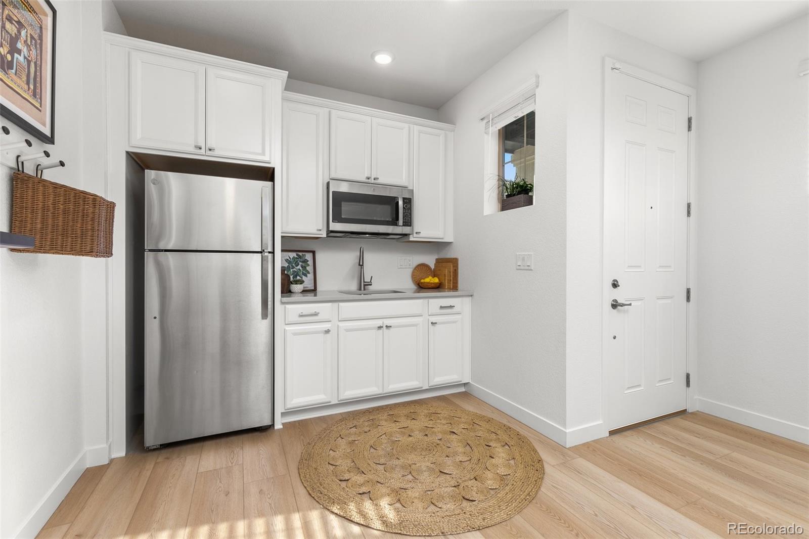 6267 North Florence Way Denver, CO 80238 - Photo 17 of 41 a kitchen with a refrigerator stove and white cabinets