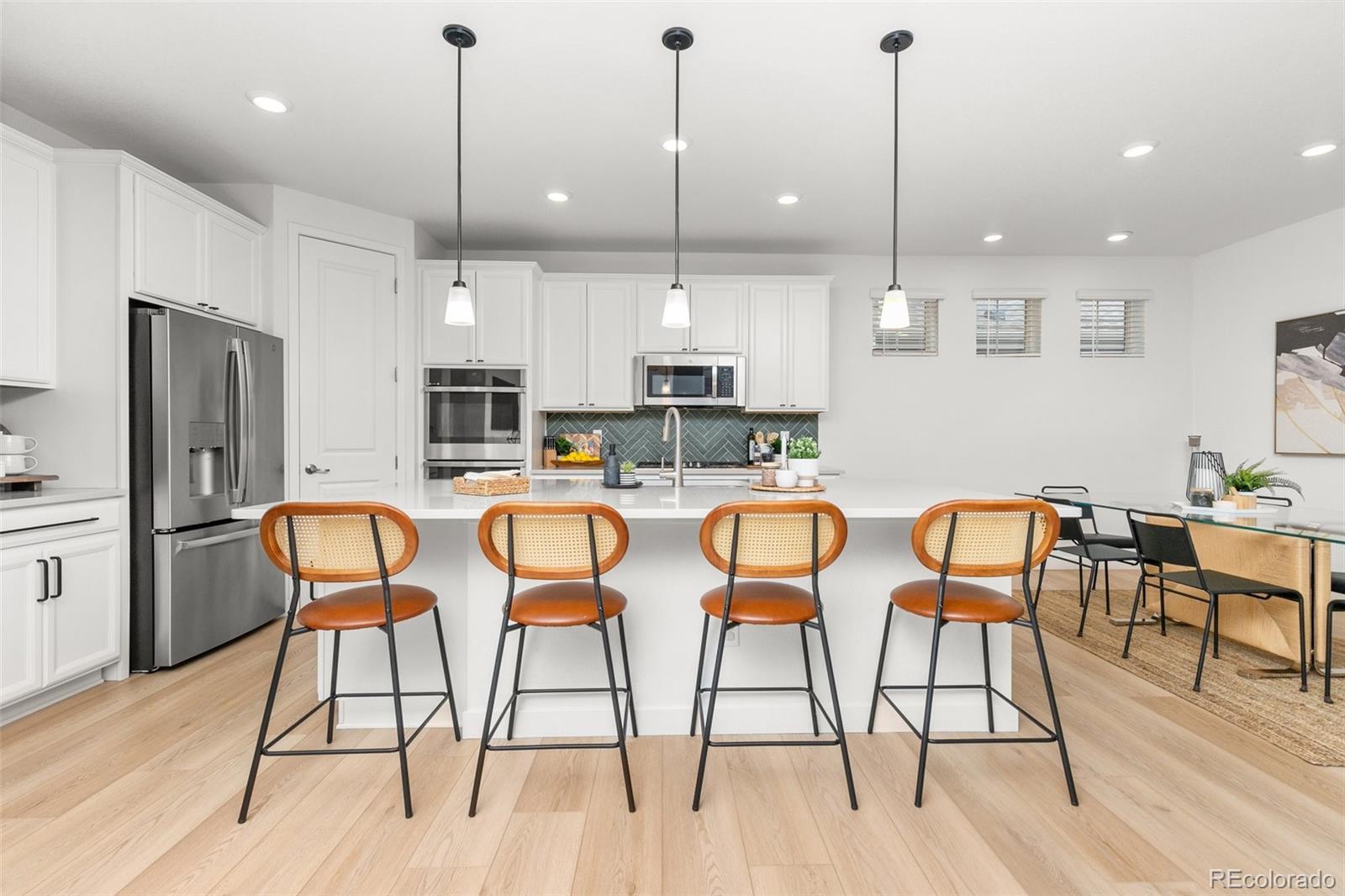 6267 North Florence Way Denver, CO 80238 - Photo 9 of 41 a kitchen with stainless steel appliances kitchen island granite countertop a table chairs stove and refrigerator