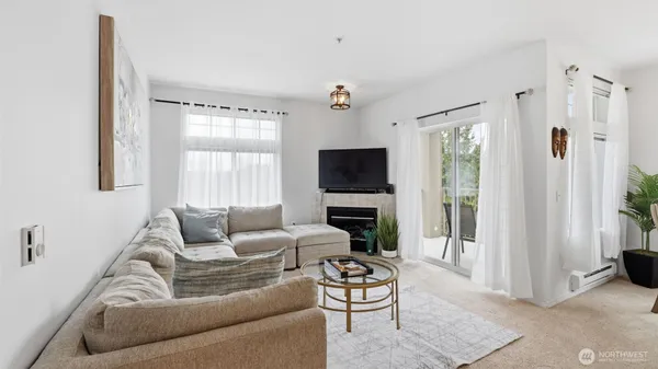a living room with furniture a flat screen tv and a window