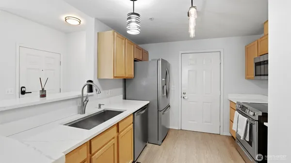 a kitchen that has a sink a refrigerator and a stove top oven