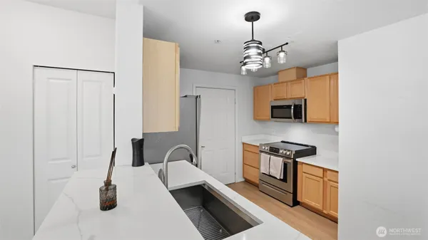 a kitchen with stainless steel appliances granite countertop a stove a sink and a refrigerator