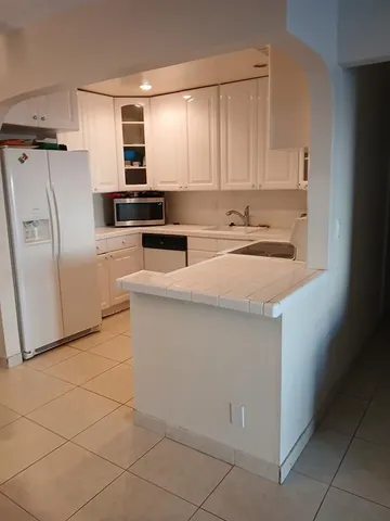 a kitchen with a refrigerator sink and cabinets