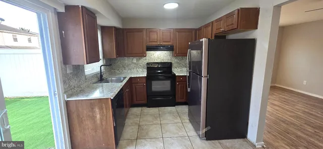 a kitchen with granite countertop a refrigerator and a sink