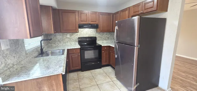 a kitchen with granite countertop a refrigerator and a granite counter tops