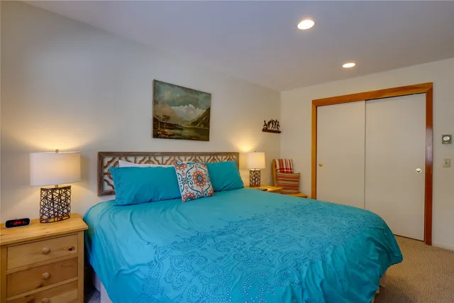 a bedroom with a bed and a lamp with the dresser