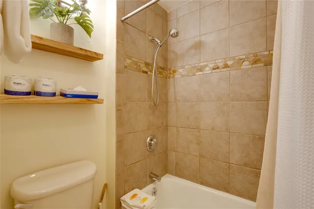 a white toilet sitting next to a bathroom sink and a shower