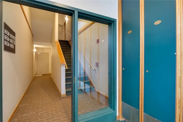 a view of a hallway with wooden floor and staircase