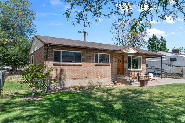 9902 South Poppy Lane Sandy, UT 84094 - Photo 2 of 25 Brick ranch-style residence featuring a covered front entry, attached carport, and a manicured front lawn