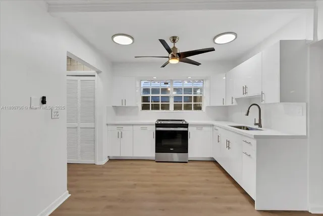 a kitchen with a sink cabinets stainless steel appliances and a window