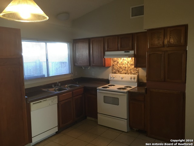 7923 Donore Place, Unit 12 San Antonio, TX 78229 - Photo 2 of 9 a kitchen with a stove and a refrigerator