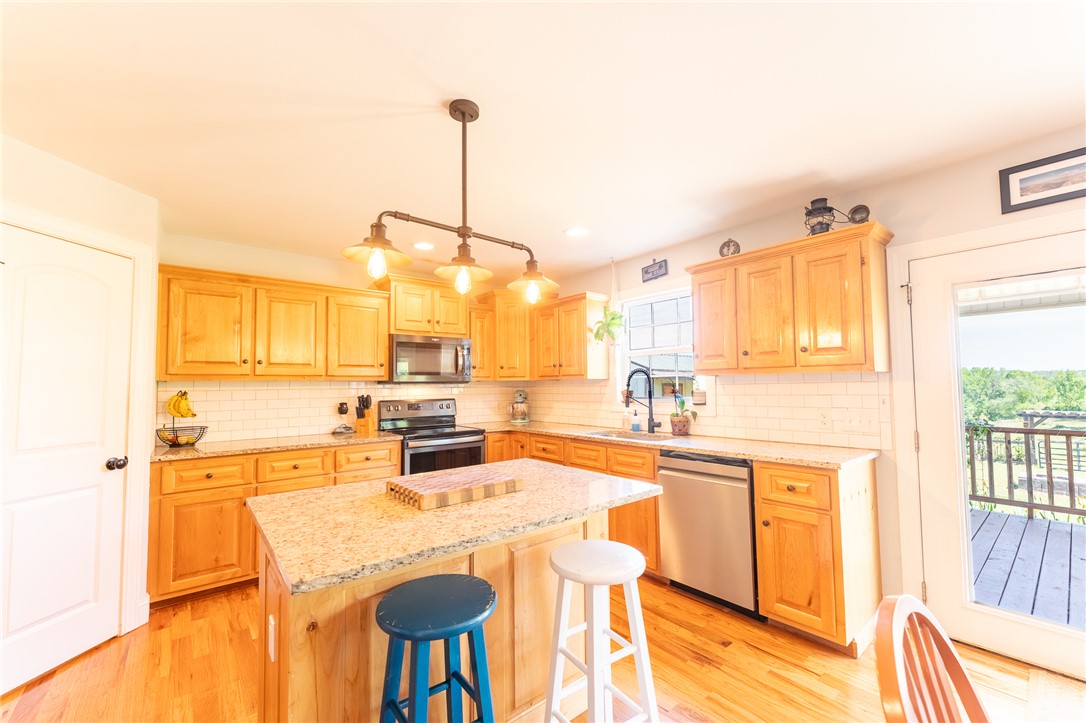 696 Mt Olivet Road Six Mile, SC 29682 - Photo 7 of 35 This bright and open kitchen features warm wood cabinetry, granite countertops, and hardwood flooring.