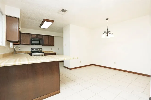 a kitchen with kitchen island a sink a stove and a microwave