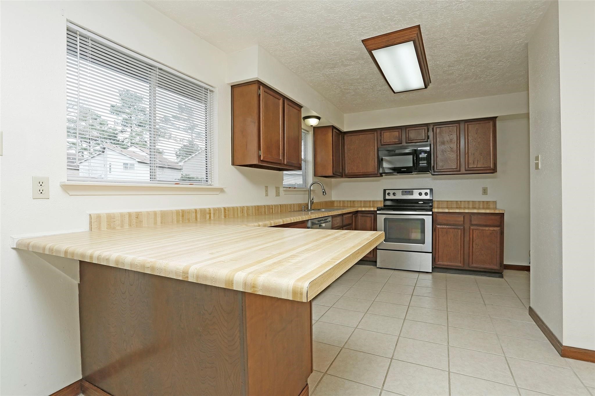 1418 Crawley Court Channelview, TX 77530 - Photo 7 of 23 a kitchen with stainless steel appliances granite countertop a sink stove and a refrigerator