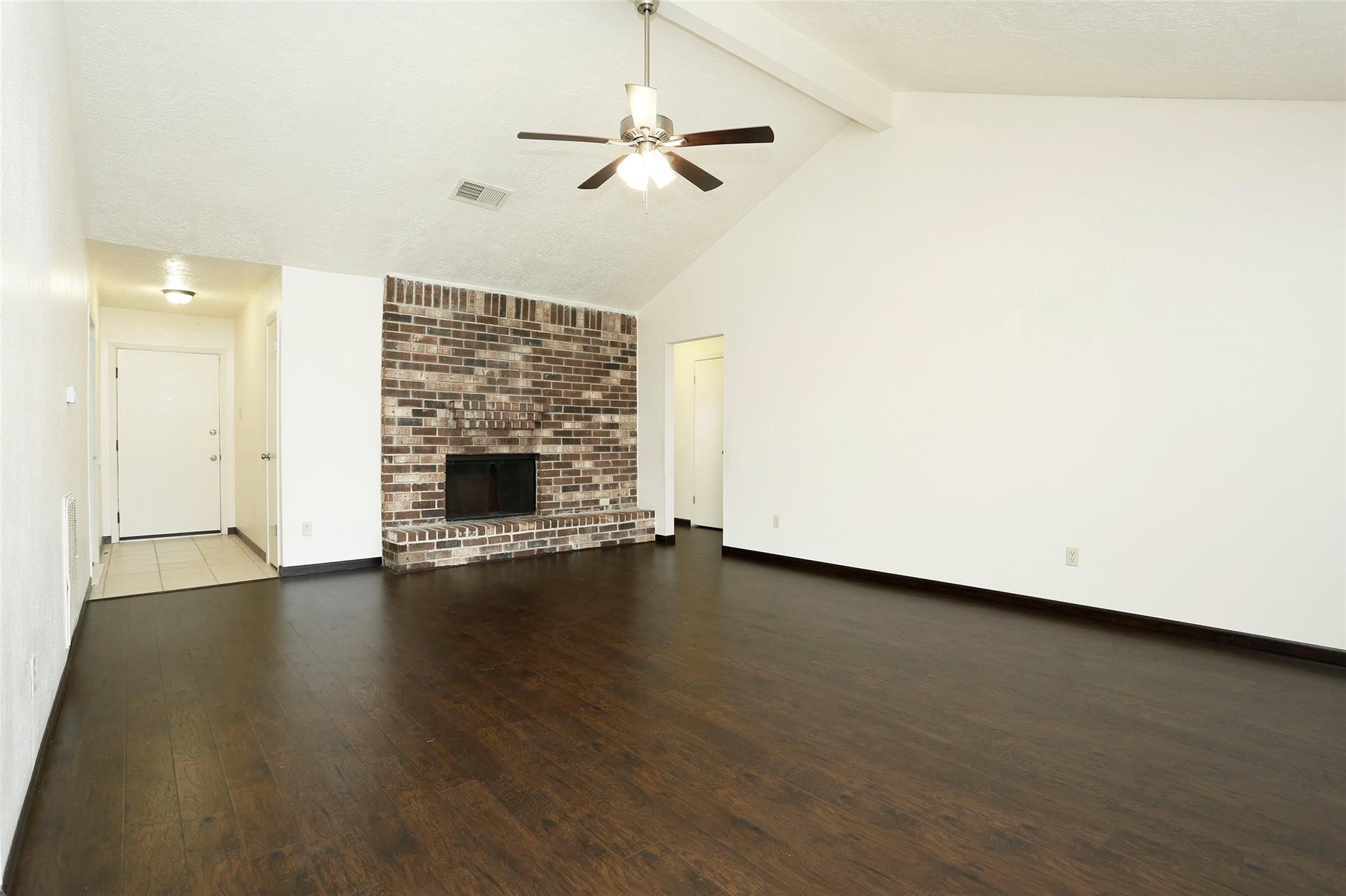 1418 Crawley Court Channelview, TX 77530 - Photo 10 of 23 an empty room with wooden floor fireplace and windows
