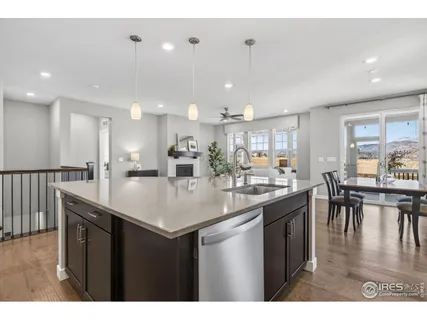 a kitchen with stainless steel appliances granite countertop a stove top oven a sink a dining table and chairs