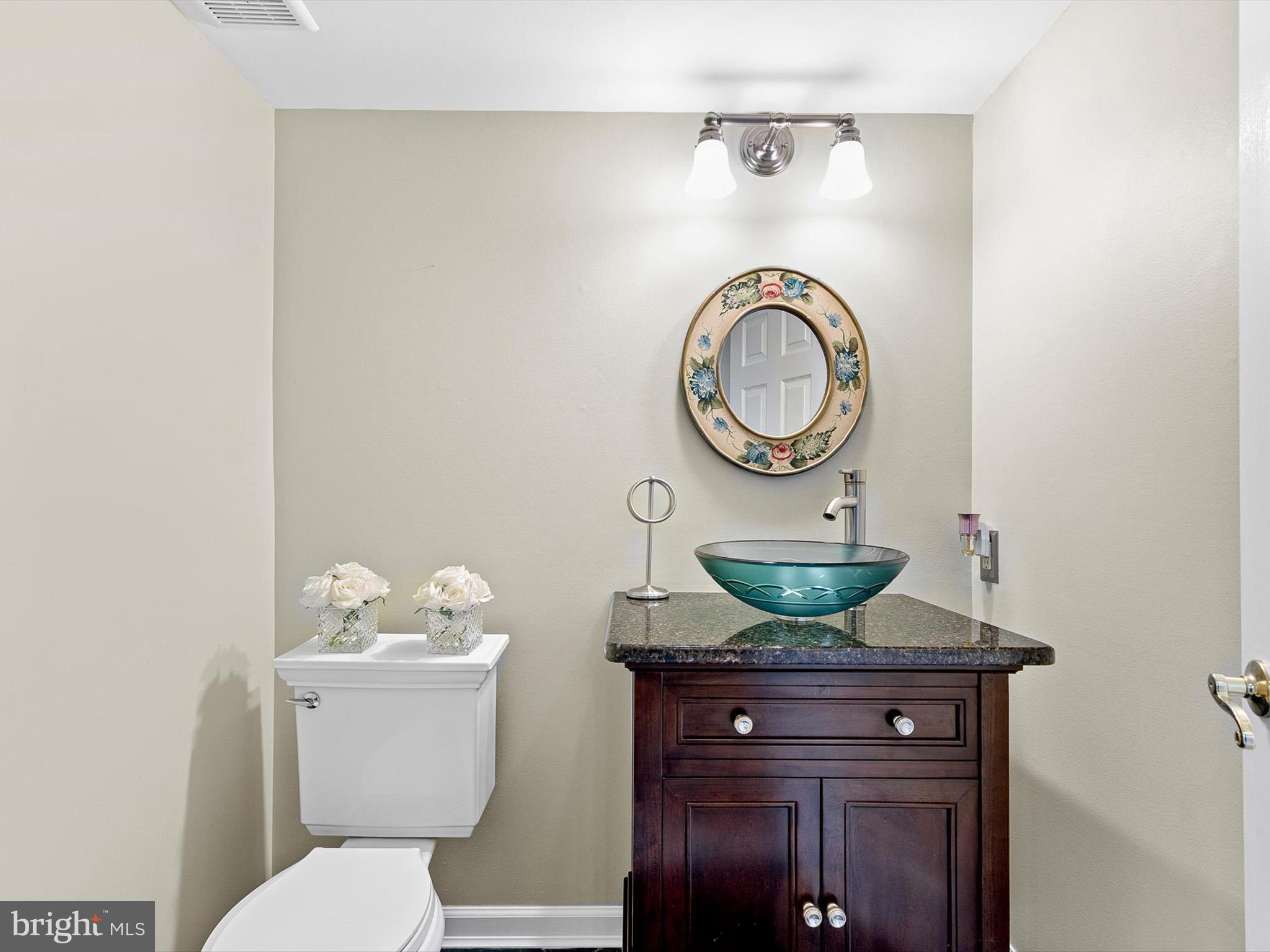 46 Westbridge Road Bear, DE 19701 - Photo 20 of 25 a bathroom with a granite countertop toilet a sink and a mirror