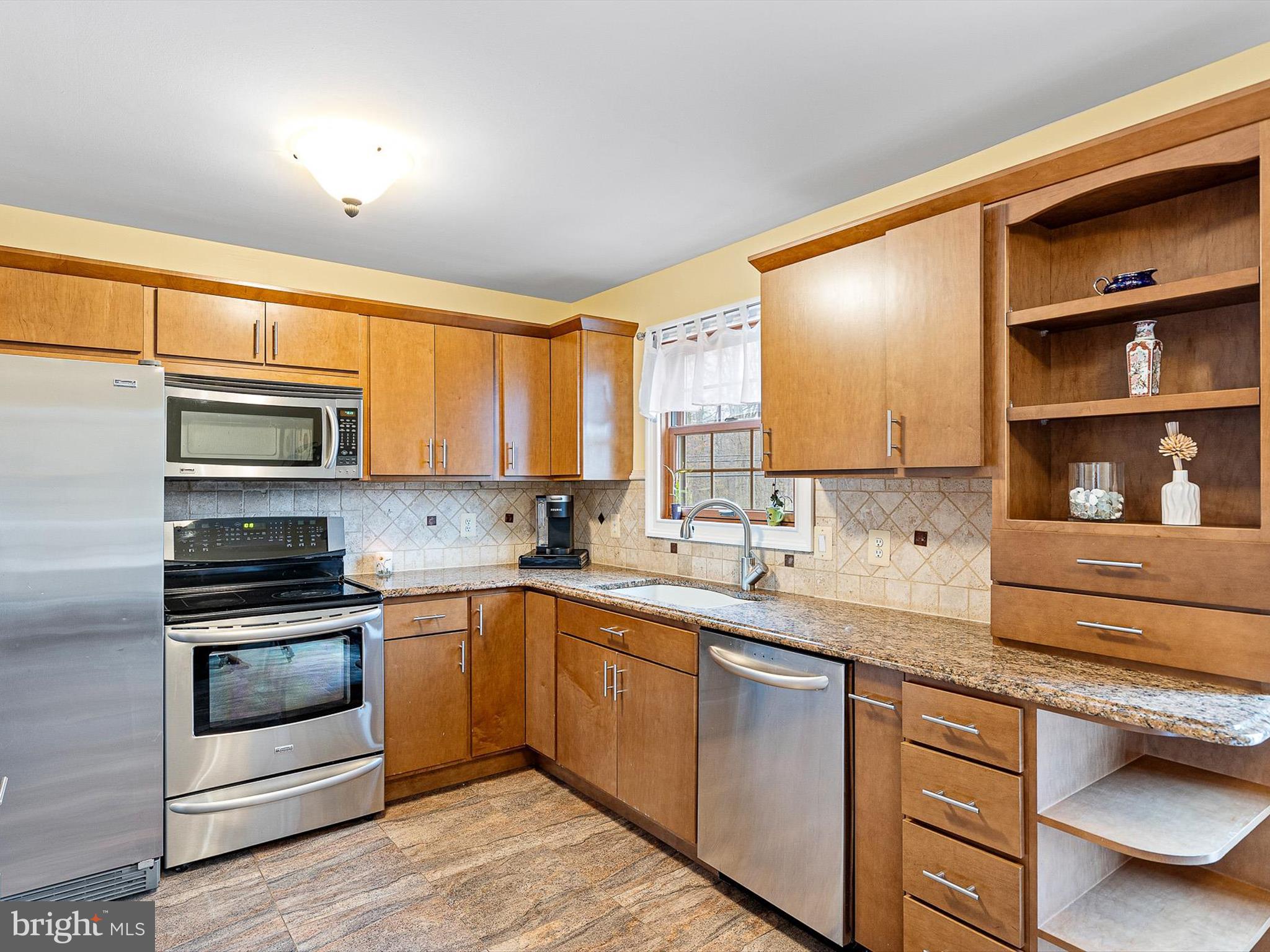 46 Westbridge Road Bear, DE 19701 - Photo 6 of 25 a kitchen with stainless steel appliances granite countertop a stove a sink and a microwave