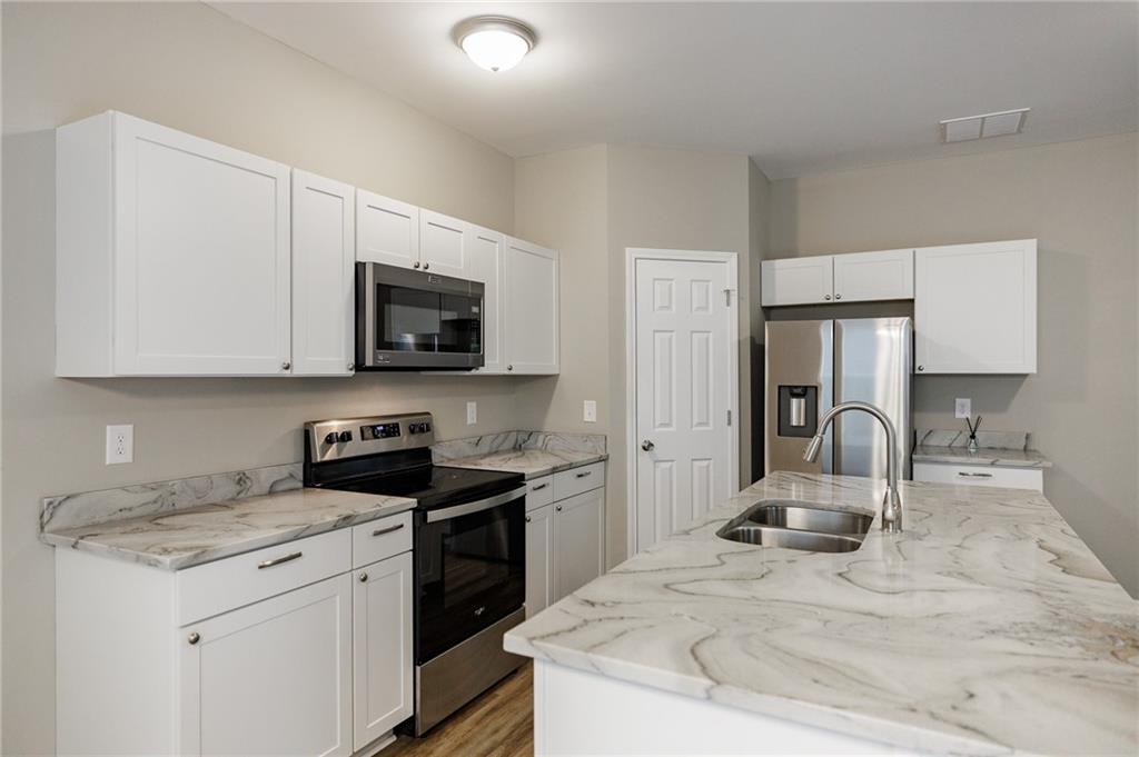 103 Three Rivers Court Hull, GA 30646 - Photo 14 of 40 a kitchen with granite countertop a sink stove and refrigerator