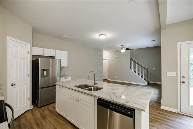 a kitchen with granite countertop a sink and refrigerator