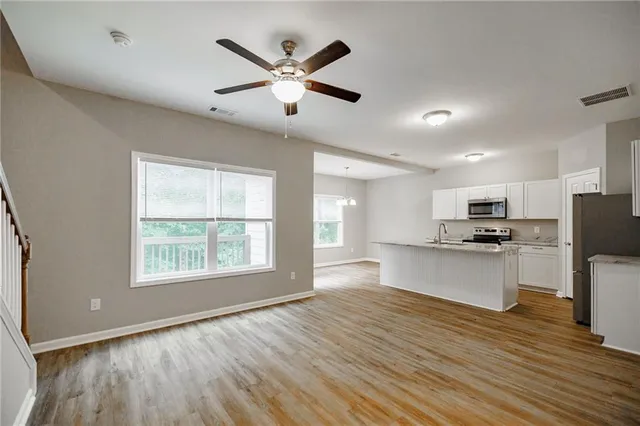 a view of kitchen with sink microwave refrigerator and stove with wooden floor