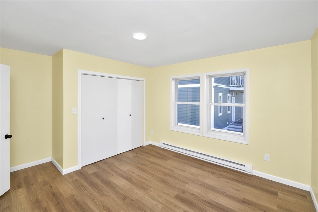 11 Greendale Road, Unit 2 Boston, MA 02126 - Photo 15 of 25 a view of an empty room with wooden floor and a window
