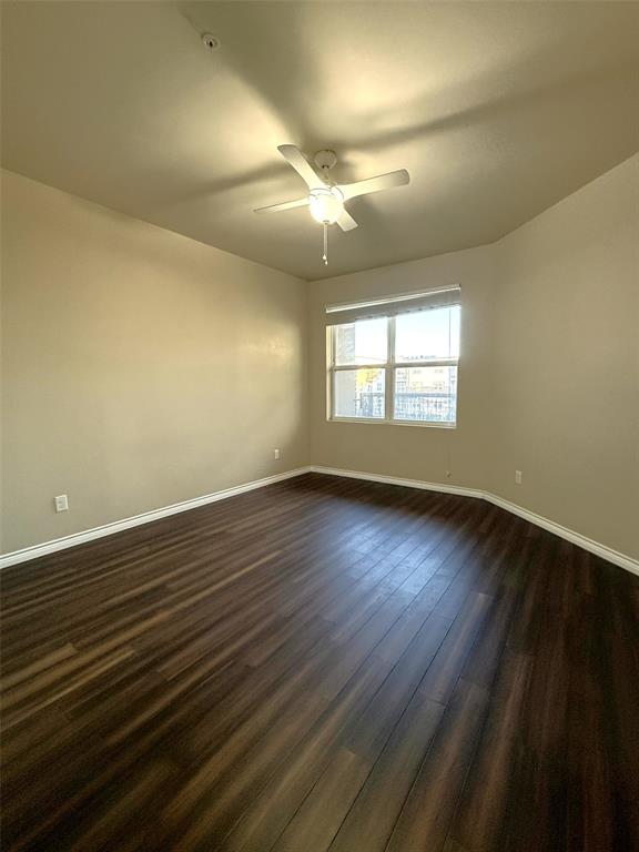 1100 West Trinity Mills Road, Unit 3039 Carrollton, TX 75006 - Photo 11 of 25 an empty room with wooden floor and windows