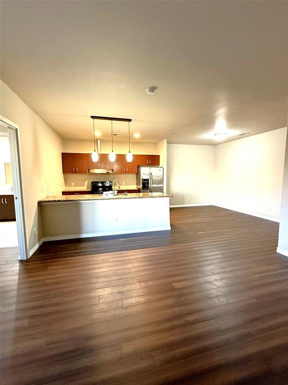 1100 West Trinity Mills Road, Unit 3039 Carrollton, TX 75006 - Photo 24 of 25 a view of a kitchen with kitchen island a sink wooden floor and black appliances