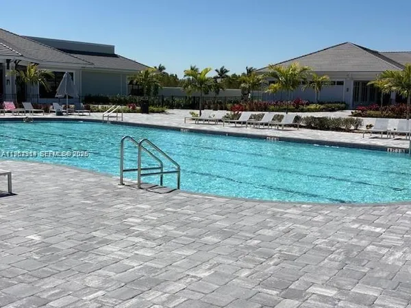 a view of a swimming pool with lawn chairs under an umbrella