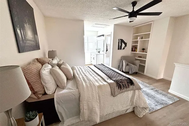 a bedroom with a bed couches and a flat tv screen