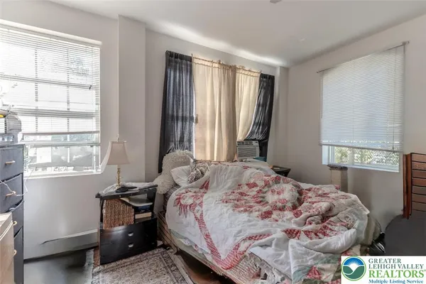 a bedroom with a bed and a window with chair
