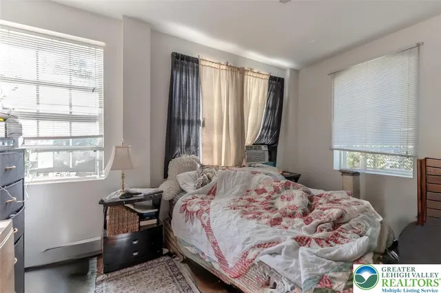 a bedroom with a bed and a window with chair