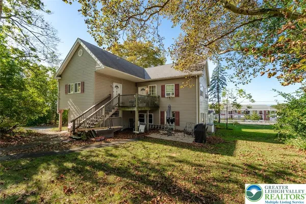 a view of a house with backyard and trees