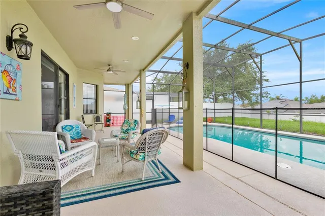 a living room with a floor to ceiling window and furniture