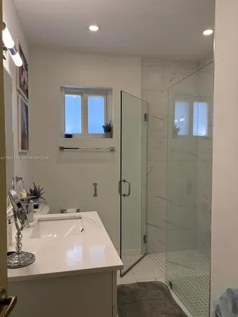 a bathroom with a sink a shower and a mirror