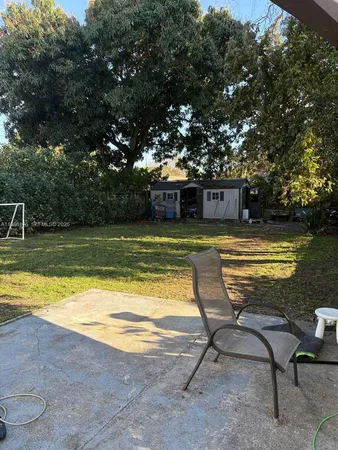 a view of a swimming pool with lawn chairs under an umbrella