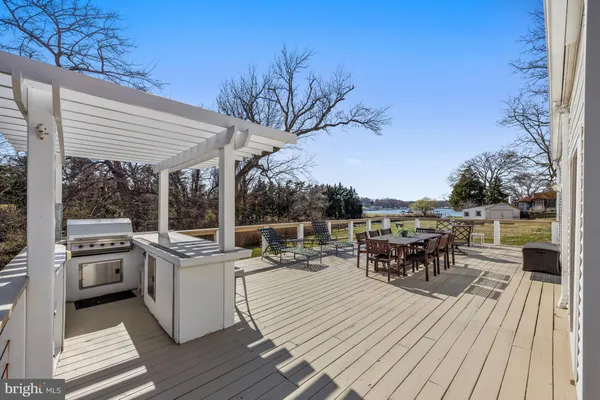 a view of a roof deck with table and chairs wooden floor and fence